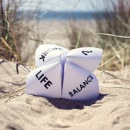 Origami fortune teller on vacation at the beach concept for work life balance choices