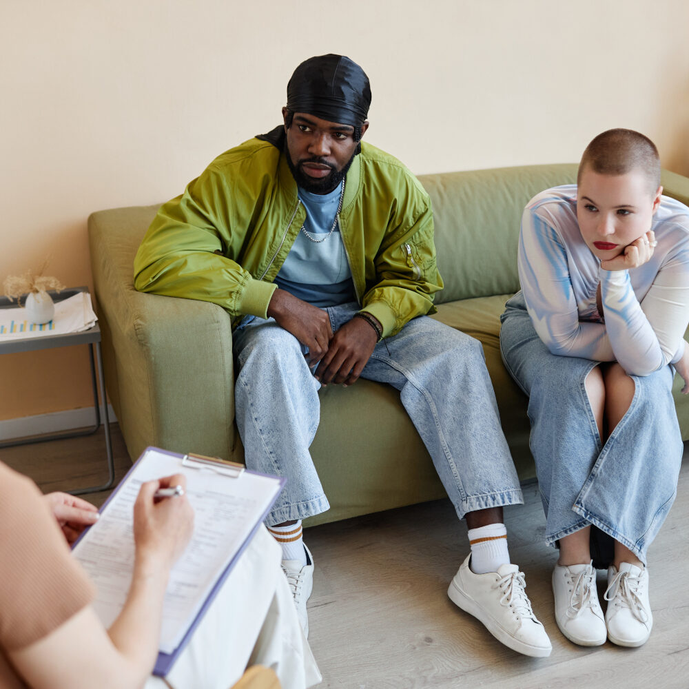Young couple talking to psychologist at meeting